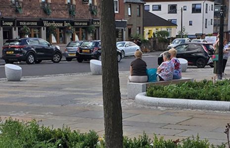 new-balloch-square-after-refurbishment-with-people-sitting-on-benches-cars-parked-and-a-cyclist-on-road
